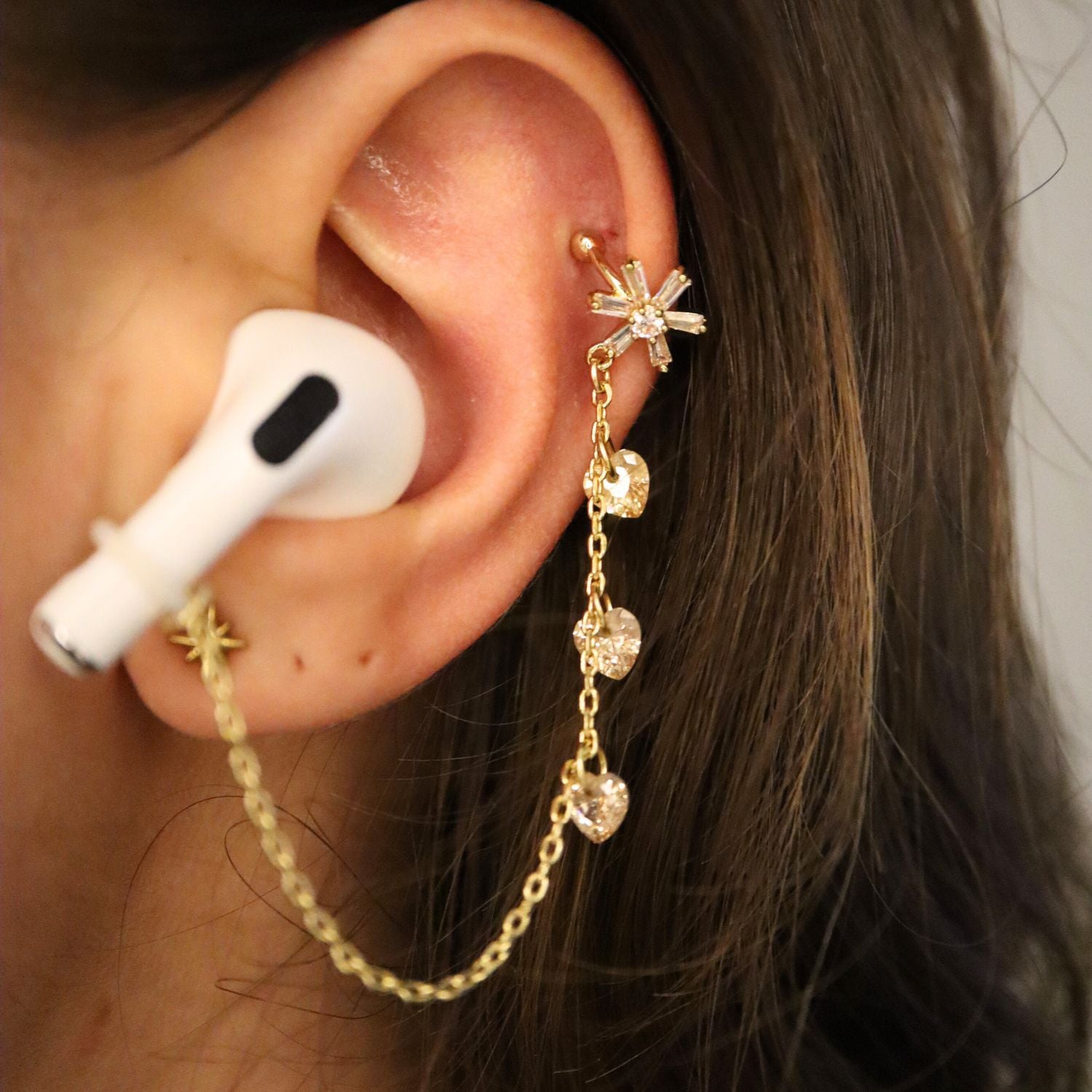 Earcuffs Voor Oordopjes (vlok hartjes) Goudkleurig op model met Airpods